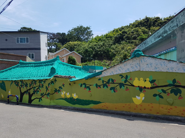 제전장어마을의 초록색 바탕의 새가 그려져있는 벽화 사진